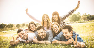 Friends group having fun together with self portrait on grass me